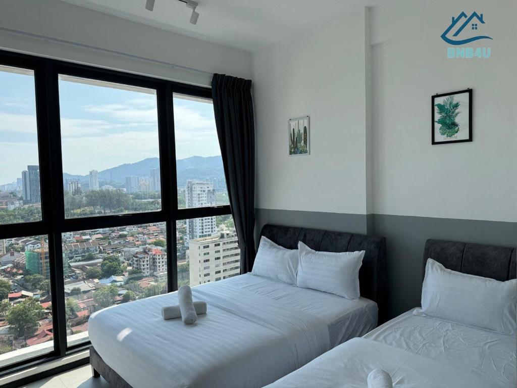 two beds in a room with a large window at Urban Suites @ George Town Penang by BNB4U in George Town