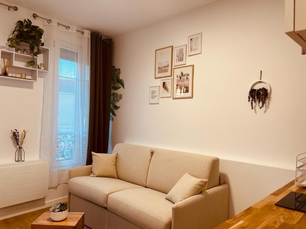 ein Wohnzimmer mit einem Sofa und einem Fenster in der Unterkunft Mignon petit studio 16m2 in Les Lilas