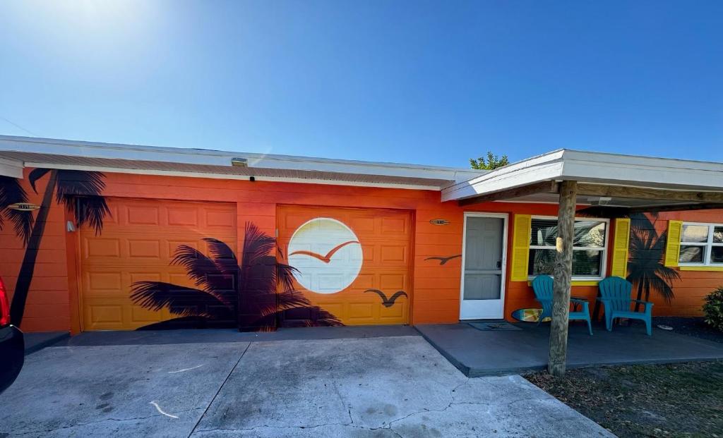ケープ・カナベラルにあるSunny Delight Iの椰子の木が描かれたオレンジ色のガレージ