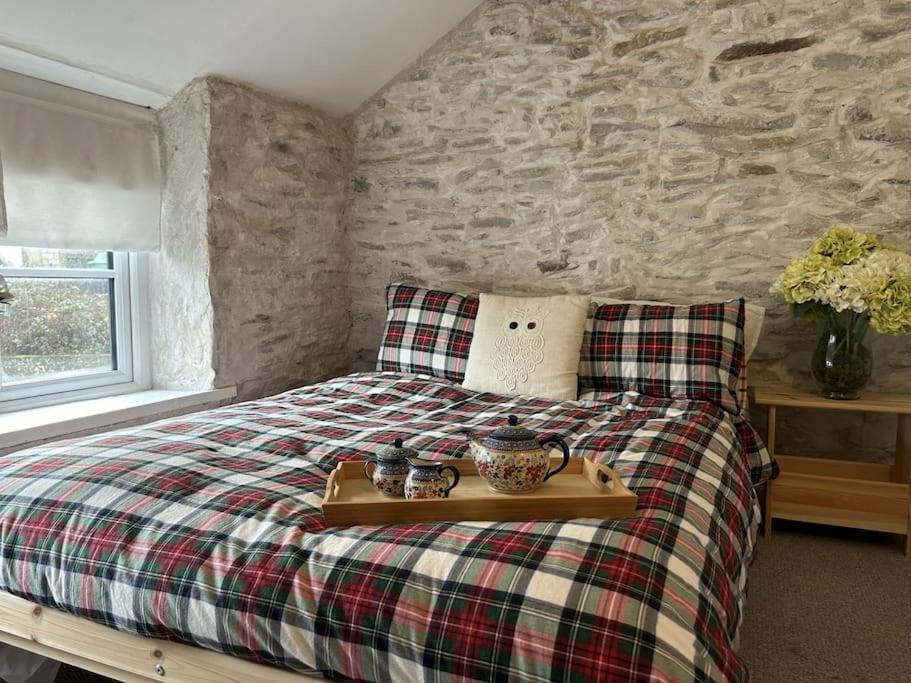 a bedroom with a bed with a tray on it at Little Cottage, Big Character in Pontypridd
