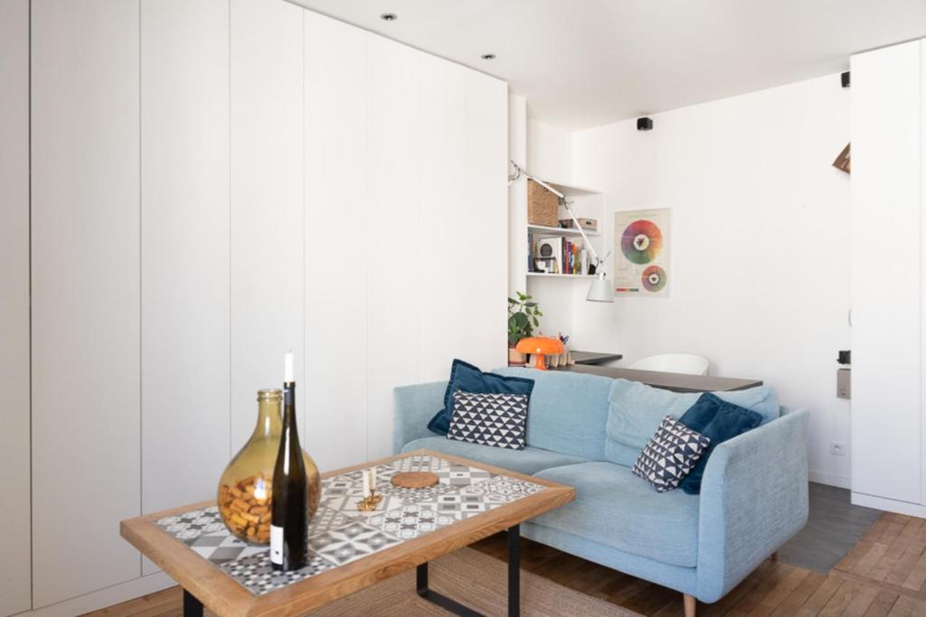 パリにあるModern apartment in Parisのリビングルーム(青いソファ、テーブル付)