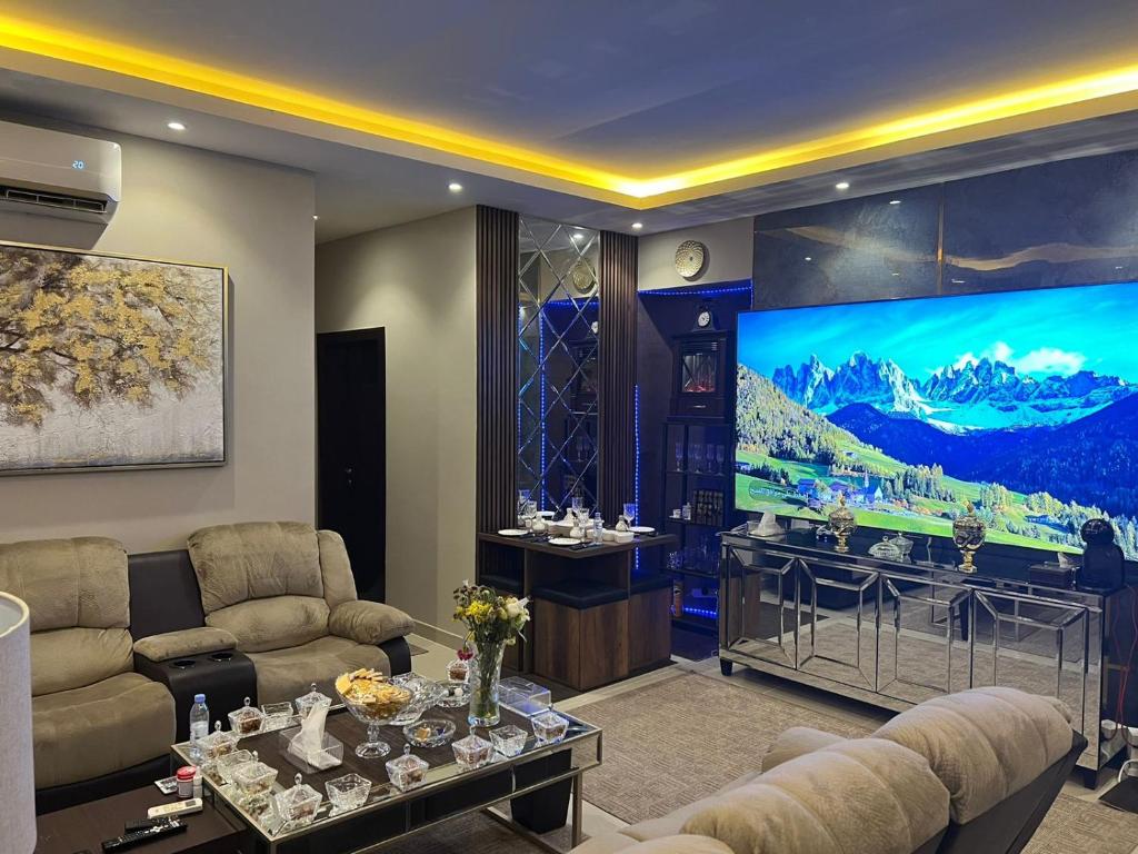 sala de estar con TV, sofá y mesa en كمباوند السليمانية en Riad