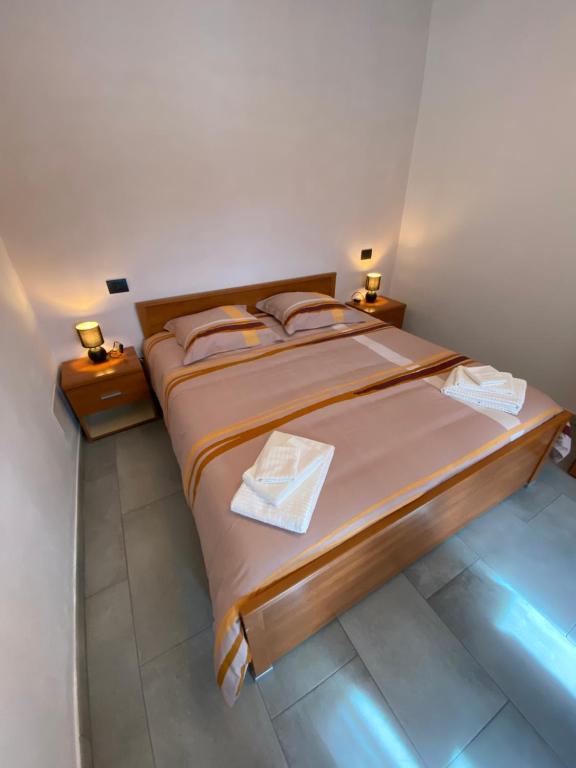een slaapkamer met een groot bed met 2 nachtkastjes bij I Limoni Casa Vacanza in Castelletto sopra Ticino