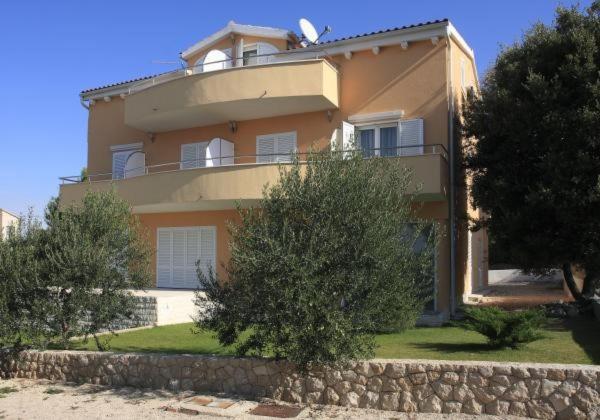 una grande casa con un balcone sopra di Apartments Kodzoman a Brodarica