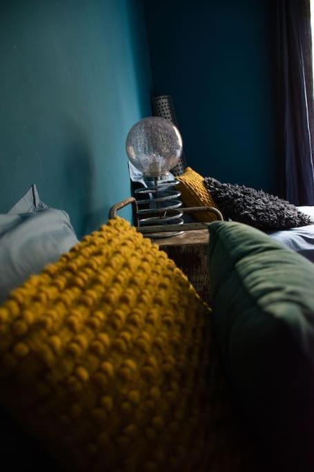 - une fermeture d'un lit avec une couverture et une lampe dans l'établissement Une pause en Provence au Village des antiquaires de la Gare, à LʼIsle-sur-la-Sorgue