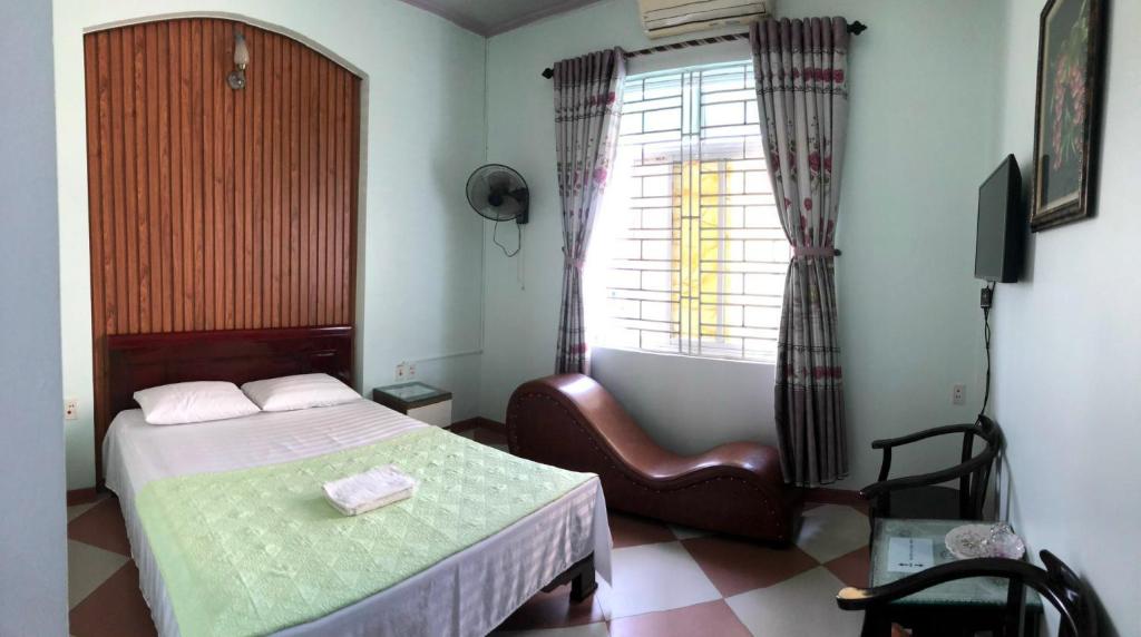 Sơn Tây的住宿－Ninh Nguyệt Motel，卧室配有床、椅子和窗户。