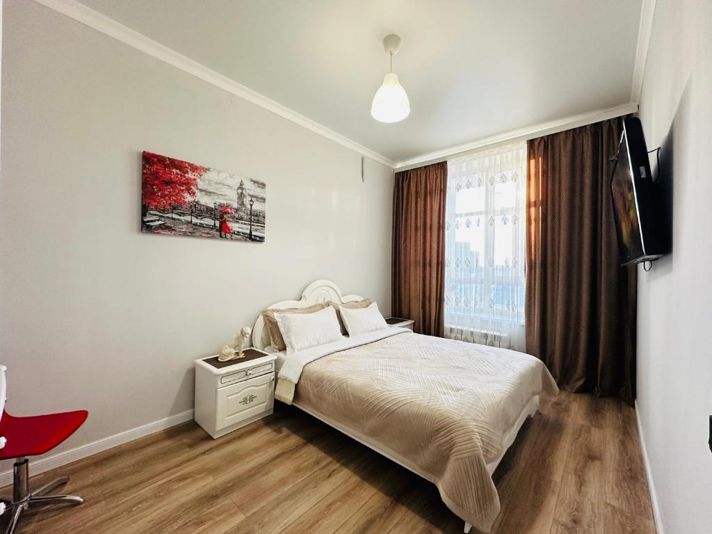 1 dormitorio blanco con 1 cama y 1 silla roja en Grand champion en Astaná