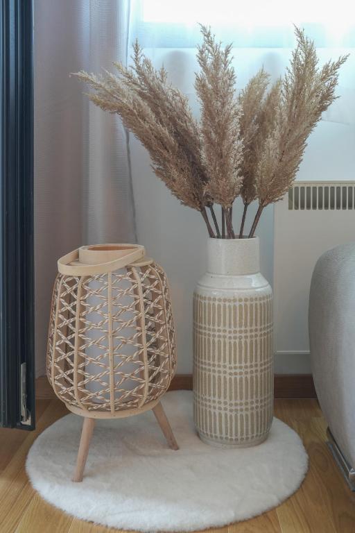 a vase with a plant in it next to a table at Apartment Forma in Zlatibor