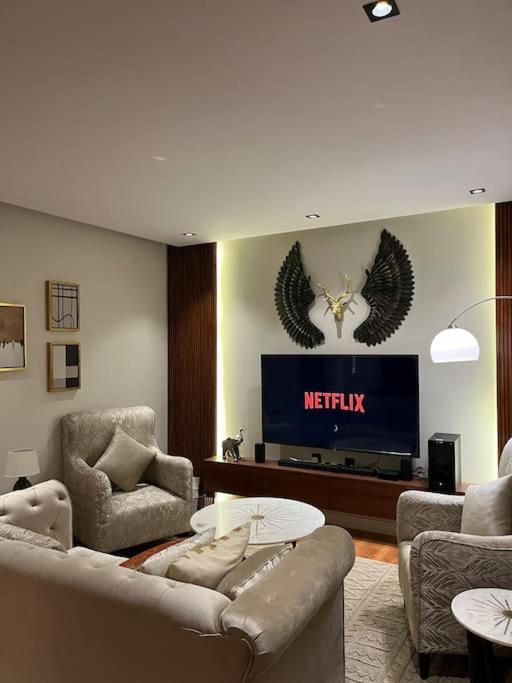 sala de estar con sofá y TV en شقة حي الخالدية مع دخول ذاتي, en Al Jubail