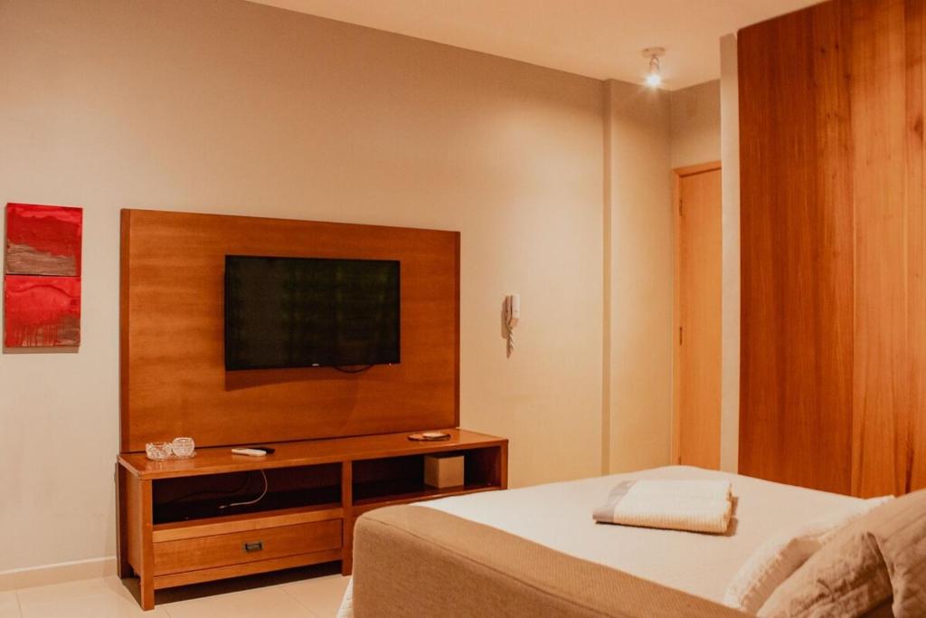 a bedroom with a bed and a flat screen tv at Studio Nova Aliança 603 Fatesa, Unip, Vaga, Wifi in Ribeirão Preto