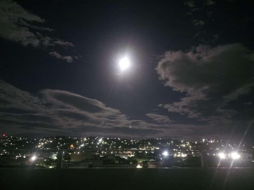 una vista de una ciudad por la noche con la luna en Hotel Arci en Cúcuta