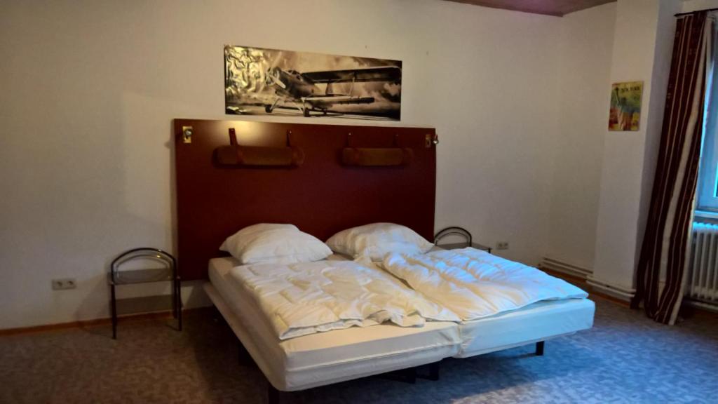 a bed in a room with a picture on the wall at Einfaches Monteurszimmer für Langzeitaufenthalte in Goslar