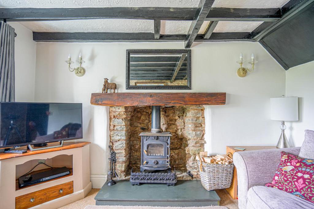 a living room with a fireplace and a stove at Cosy cottage in rural Ludlow, Seifton View Cottage Culmington in Culmington