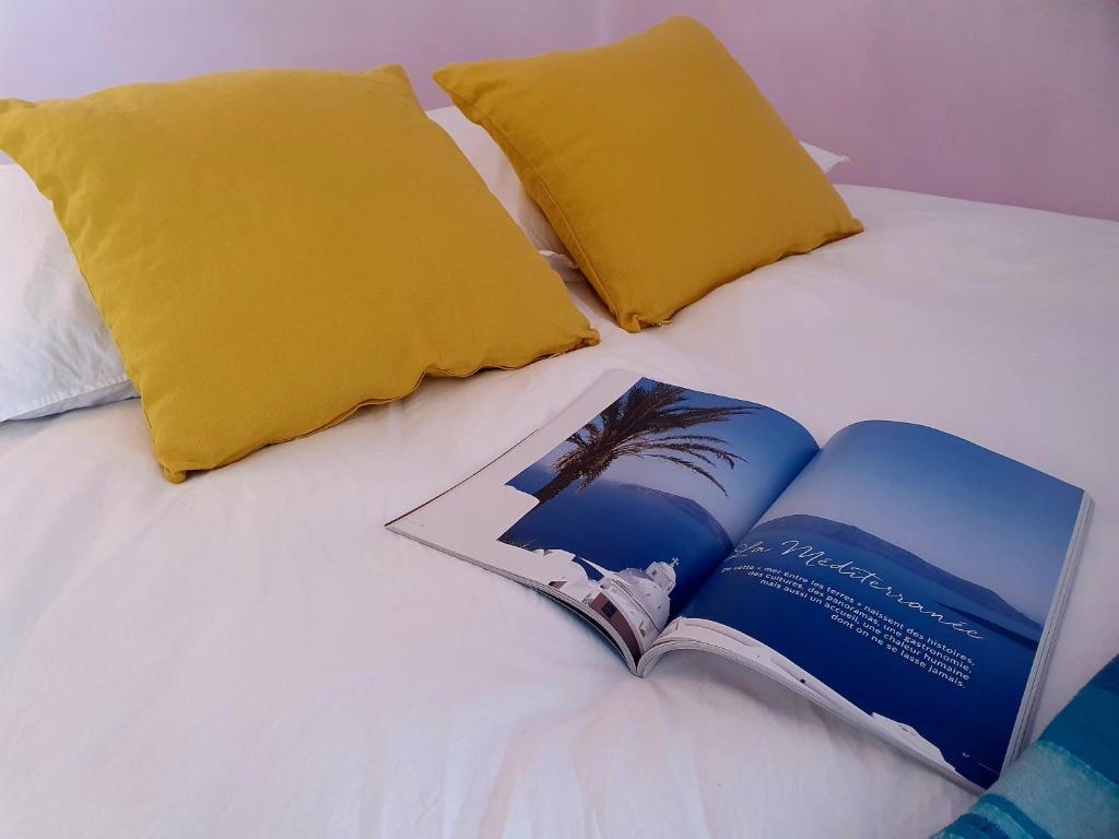 a book sitting on top of a bed with two pillows at Vue sur Paris in Ivry-sur-Seine
