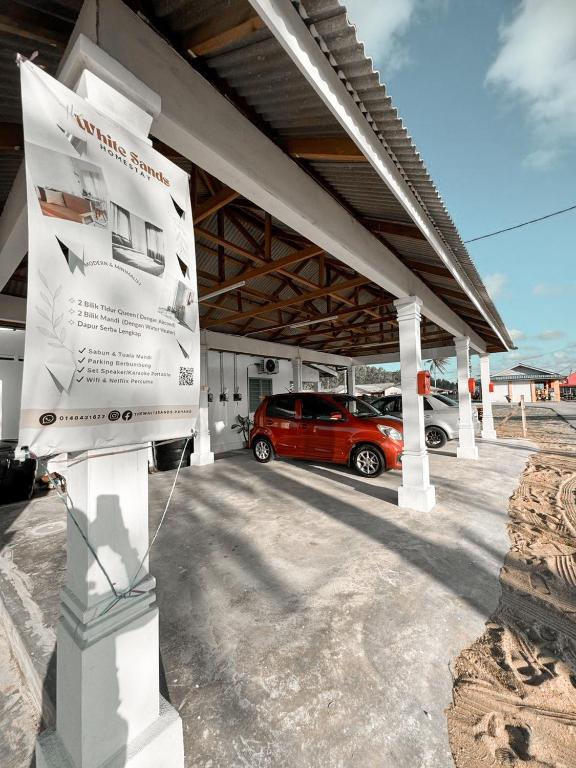 a parking lot with a red car parked under a building at The White Sands Homestay Pekan Pahang in Pekan