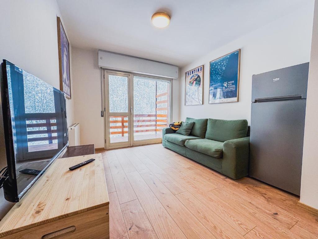 a living room with a couch and a tv at Casa Marmotta in Val di Pejo in Peio Fonti