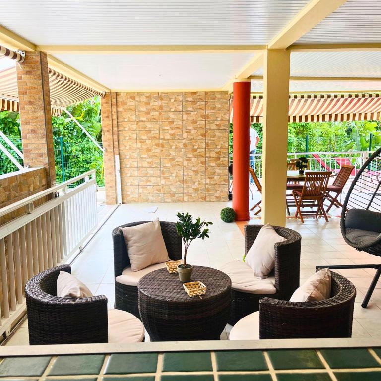 a patio with wicker chairs and a table at Villa Red Palmer -sauna jacuzzi in Gros-Morne