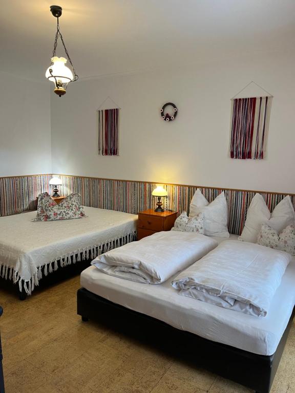 a bedroom with two beds and two tables and two lamps at Cicáskacus Vendégház in Matrafured