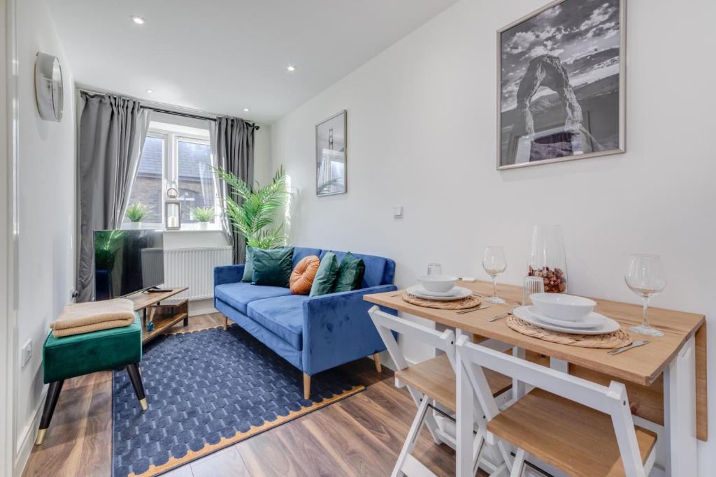 倫敦的住宿－Modern 1 Bed Apartment - Nine Elms, Battersea，客厅配有蓝色的沙发和桌子