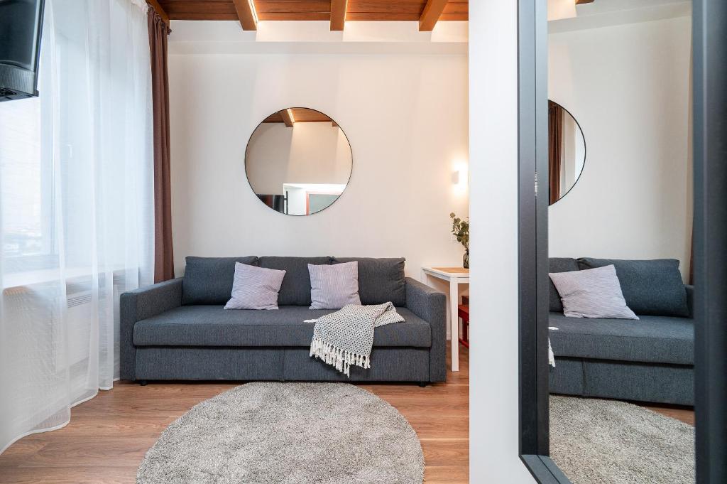 a living room with a blue couch and a mirror at Cozy studio in the city center in Vilnius