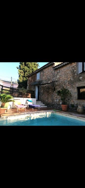 une piscine devant un bâtiment en briques dans l'établissement Grande maison en pierre dans la colline varoise, à Vidauban