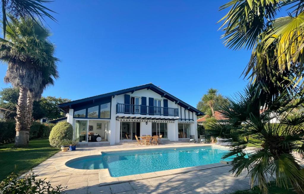 uma casa com uma piscina em frente em Villa 4 étoiles sur le Golf Makila près de Biarritz em Bassussarry