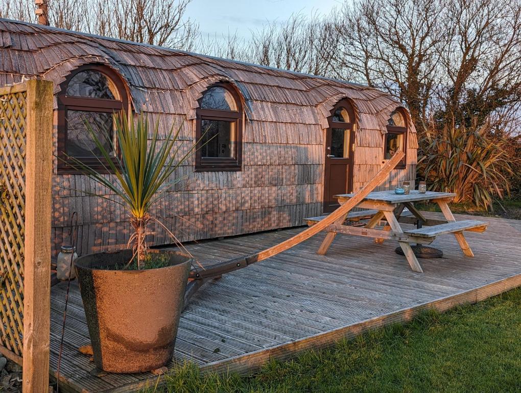 a yurt with a picnic table on a wooden deck at The Pilchard - Lydcott Glamping Cornwall, sea view in East Looe