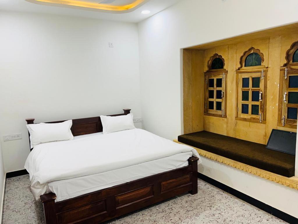 - une chambre avec un grand lit et une fenêtre dans l'établissement Hotel Golden Garh, à Jaisalmer