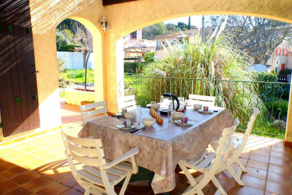une table et des chaises assises sur une terrasse dans l'établissement Family cottage facing the sea, à Six-Fours-les-Plages
