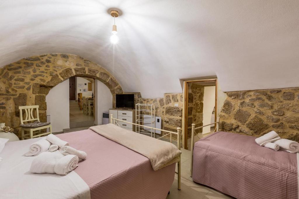 two beds in a room with a stone wall at Casa Relax in Mesagne