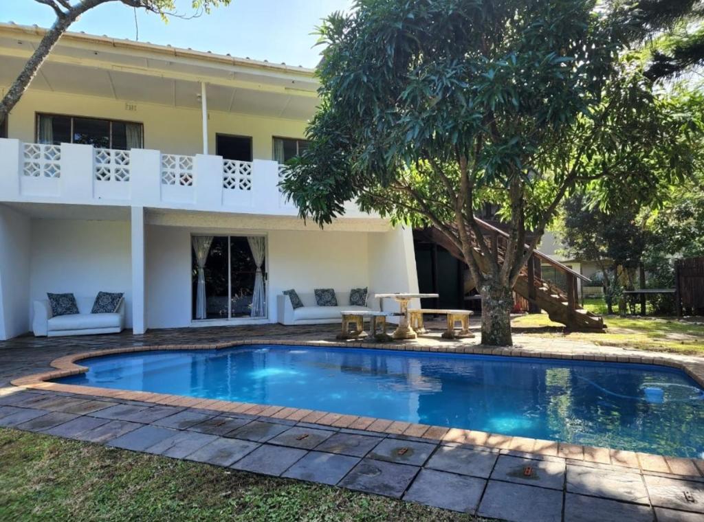a swimming pool in front of a house at Seacastle Guesthouse in Port St Johns