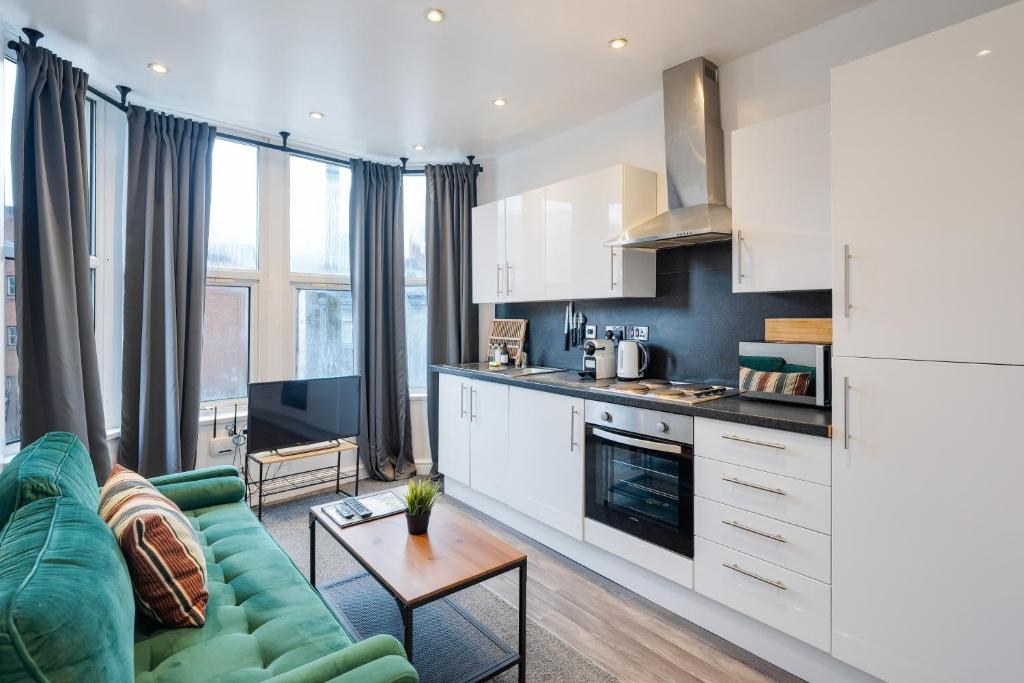 salon z zieloną kanapą i kuchnią w obiekcie 2 Bedroom Apartment Near City Centre, Uni & Parks! w Cardiff