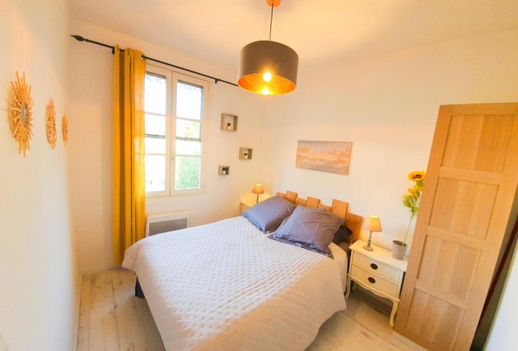 une chambre avec un lit blanc et une fenêtre dans l'établissement Studio 28m2 avec balcon, très proche de la mer, à Saint-Laurent-du-Var