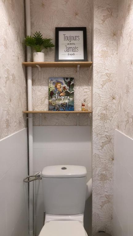 een badkamer met een toilet en een bord aan de muur bij La Boissiere in Avrillé