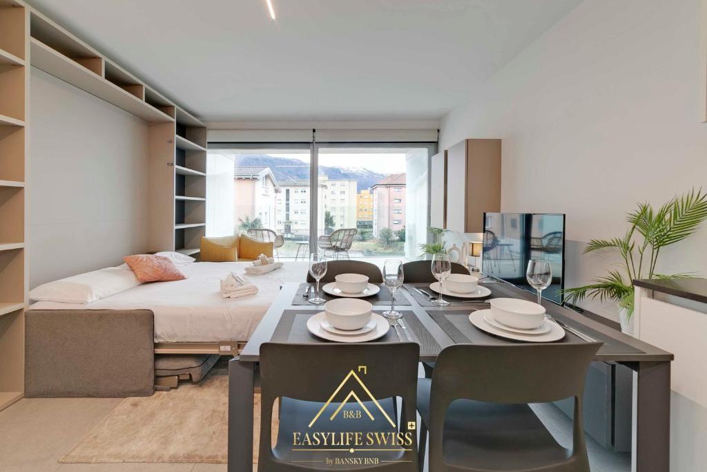 - un salon avec une table à manger et un lit dans l'établissement Avorio Wonderful and Modern Loft in Bellinzona -By EasyLife Swiss, à Bellinzone