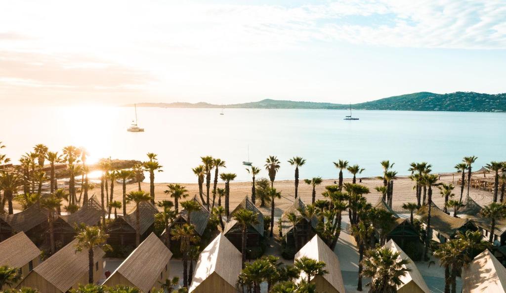 an aerial view of a resort with palm trees and a beach at Les Prairies de la Mer in Grimaud