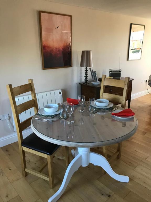 a dining room table with two chairs and a table with wine glasses at Close House Cottage in York