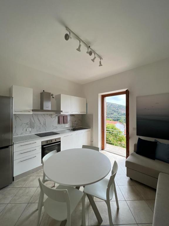 波蒙太的住宿－Pomonte house，厨房配有白色的桌子和桌椅