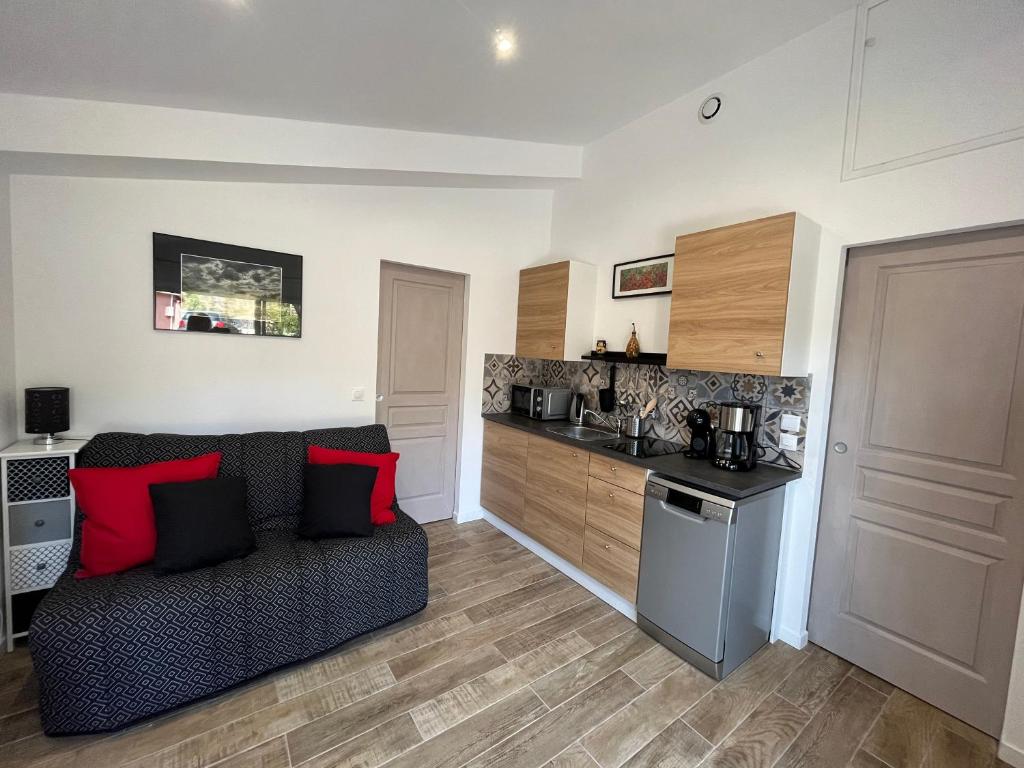 een woonkamer met een bank en een keuken bij Bel Appartement indépendant lumineux - St-Maximin in Saint-Maximin-la-Sainte-Baume
