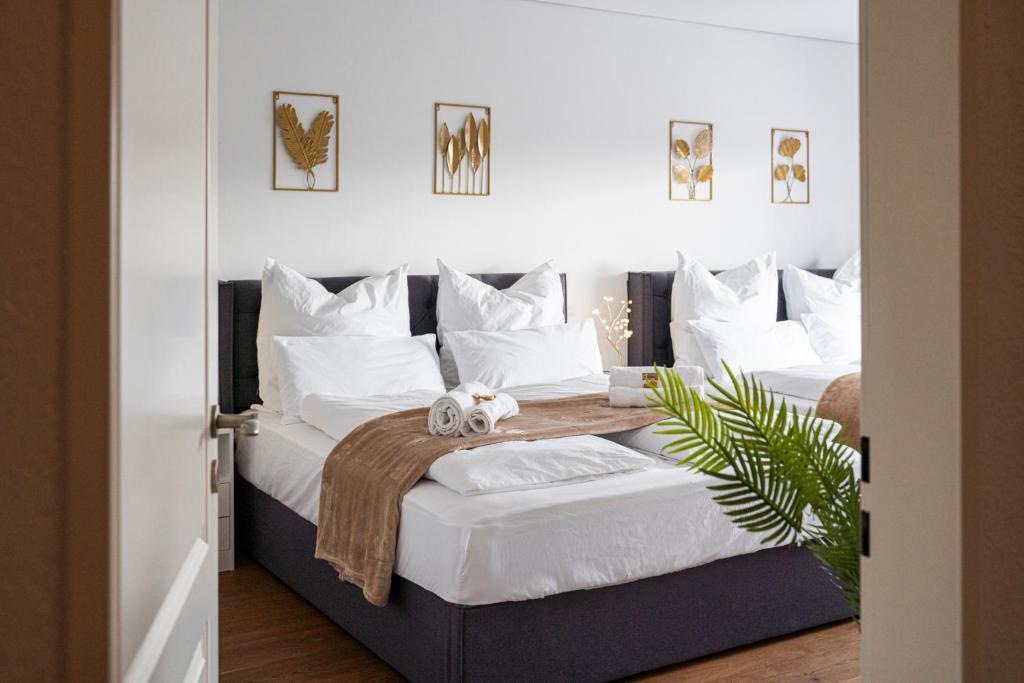1 dormitorio con 2 camas y almohadas blancas en 130m2 Loft - Dachterrasse, Netflix, Badewanne, Kaffee, en Rosenheim