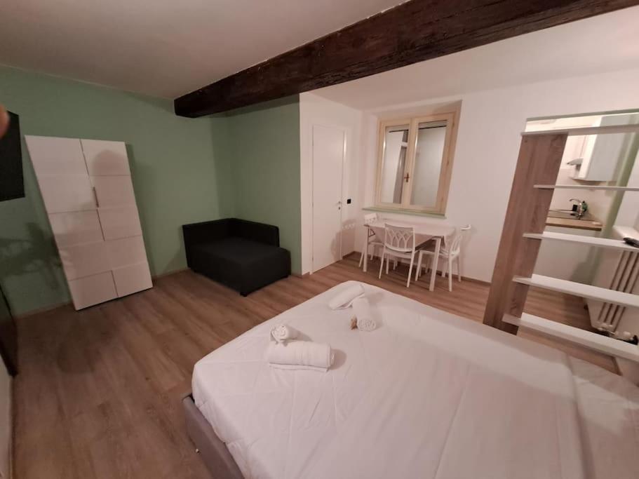 um quarto com uma grande cama branca e uma mesa em Borgo Guazzo 24 em Parma