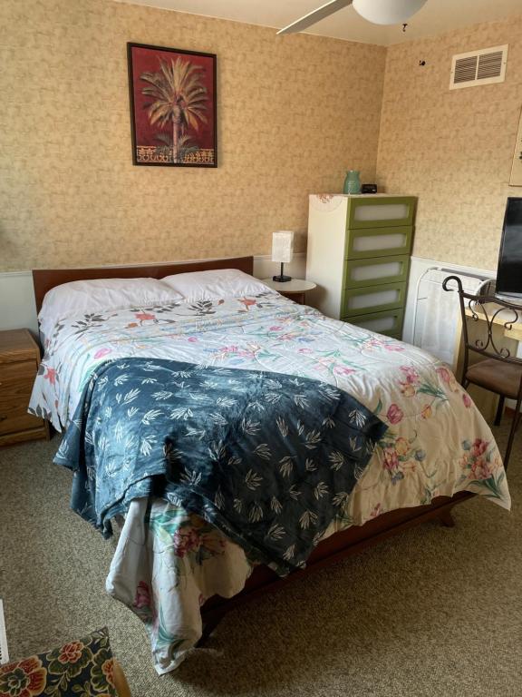 1 dormitorio con 1 cama con una foto de palmera en la pared en Comfortable stay, en Milton