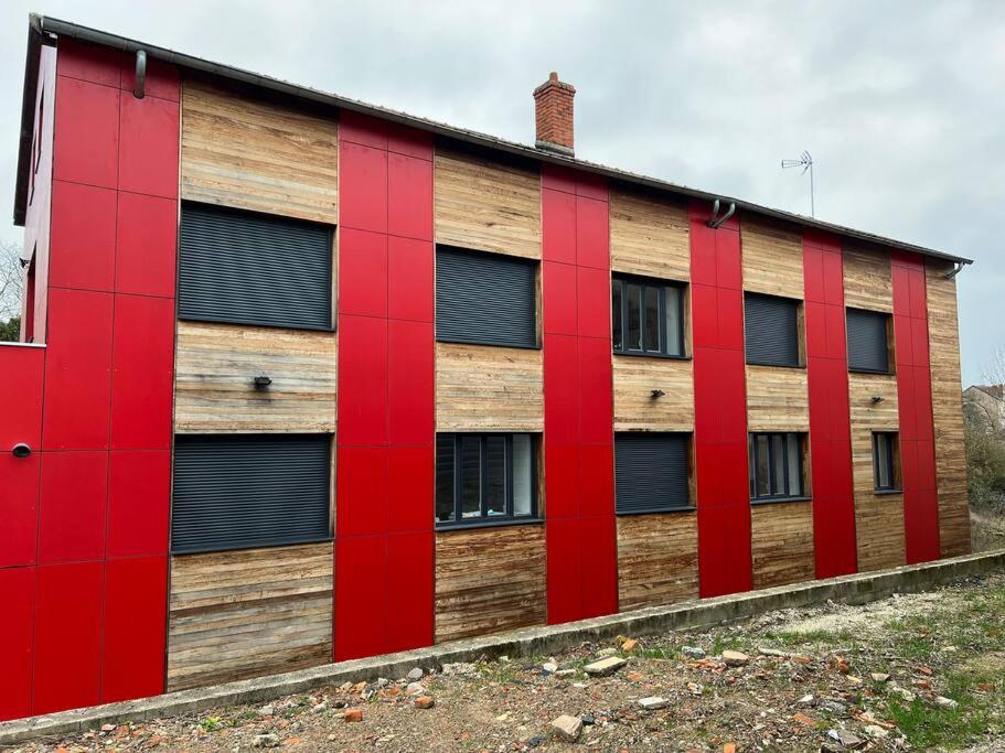 ein Holzgebäude mit roten Türen und Fenstern in der Unterkunft Studio 2 - Proche Centre-ville in Paray-le-Monial