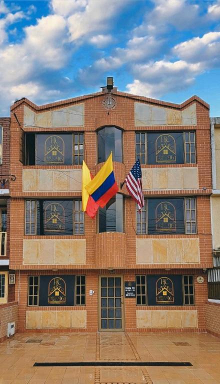 two flags flying in front of a brick building at Hotel Canela 96 in Bogotá
