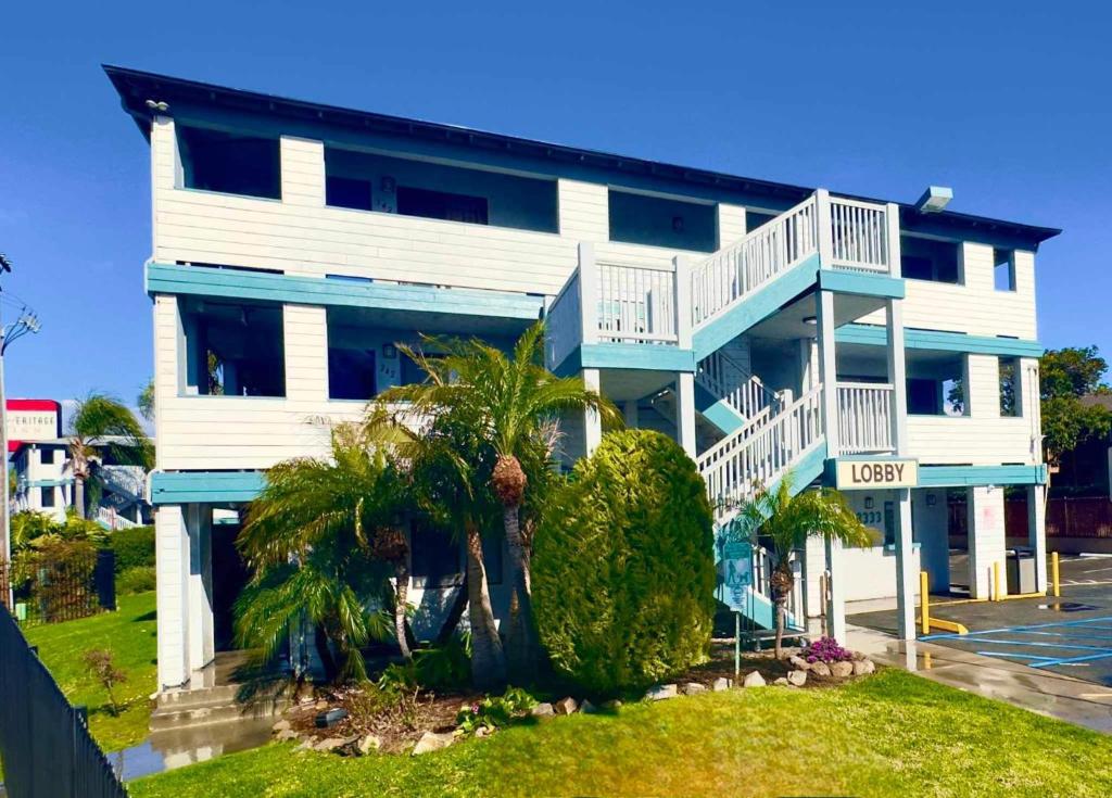 a blue and white building with palm trees in front of it at Heritage Inn San Diego in San Diego