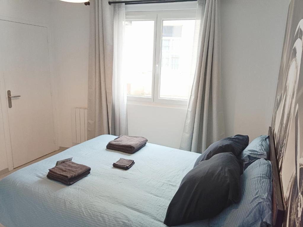 a bedroom with a bed with two towels on it at La Suite du Pilote in La Ferté-Alais