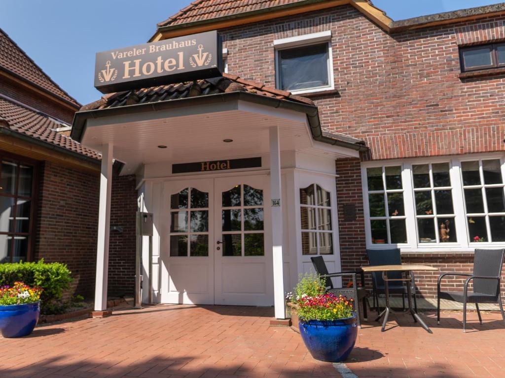 ファーレルにあるVareler Brauhaus-Hotel Varel Dangastのホテルにはドア、テーブル、椅子があります。