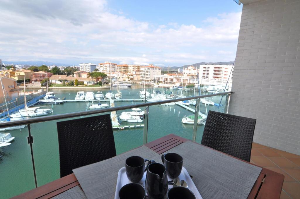 una mesa con vistas a un puerto deportivo con barcos en RNET - Apartments Roses Port Trebol, en Roses