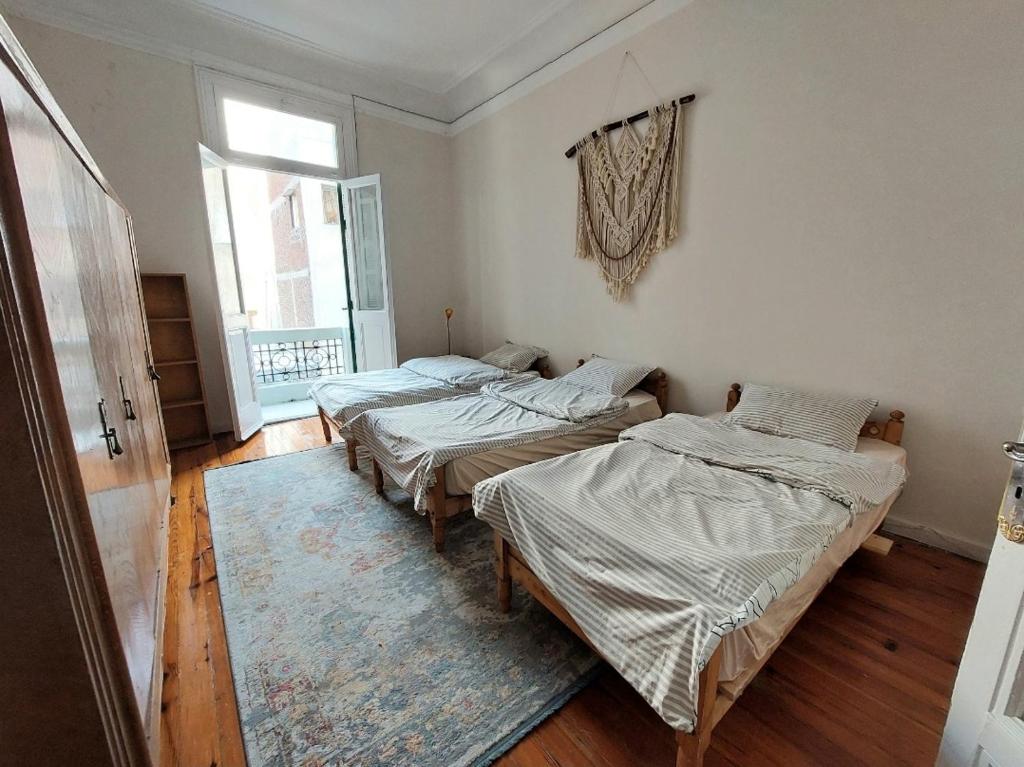 um quarto com três camas e um tapete em AL- Mazareta a private room at Shared apartment For Men only No Ladies allowed غرفة خاصة في شقة مشتركة للرجال فقط ممنوع السيدات仅限男士 女士不允许 em Alexandria