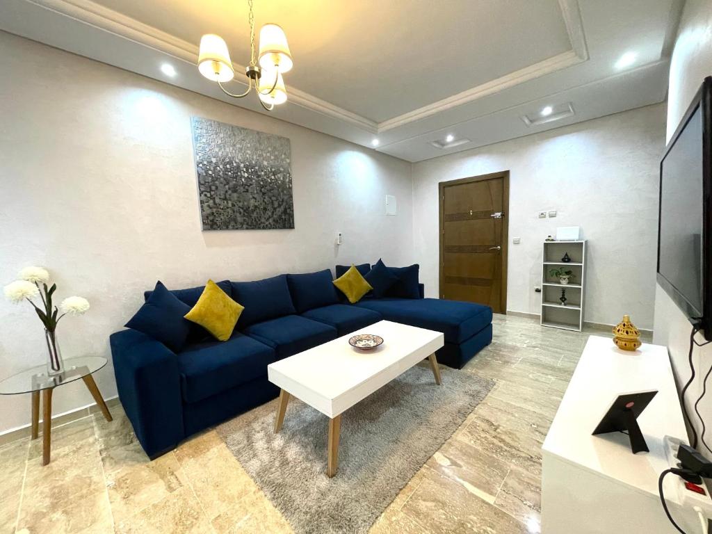 a living room with a blue couch and a table at Appartement Tanger Moulay Ismail in Tangier